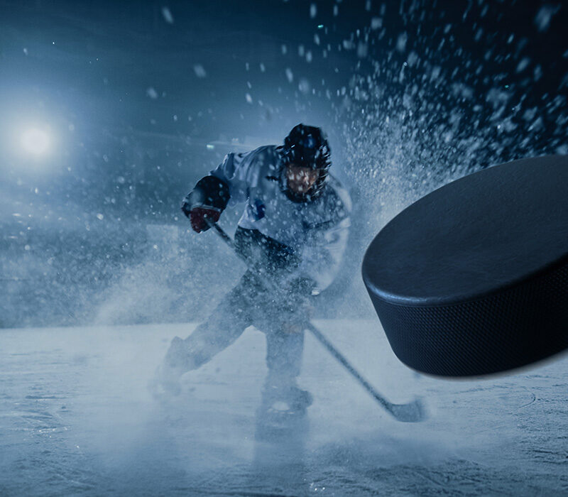 IJshockeyspeler slaat een puck weg in een sneeuwwolk, symbool voor snelle en krachtige cybersecuritybescherming