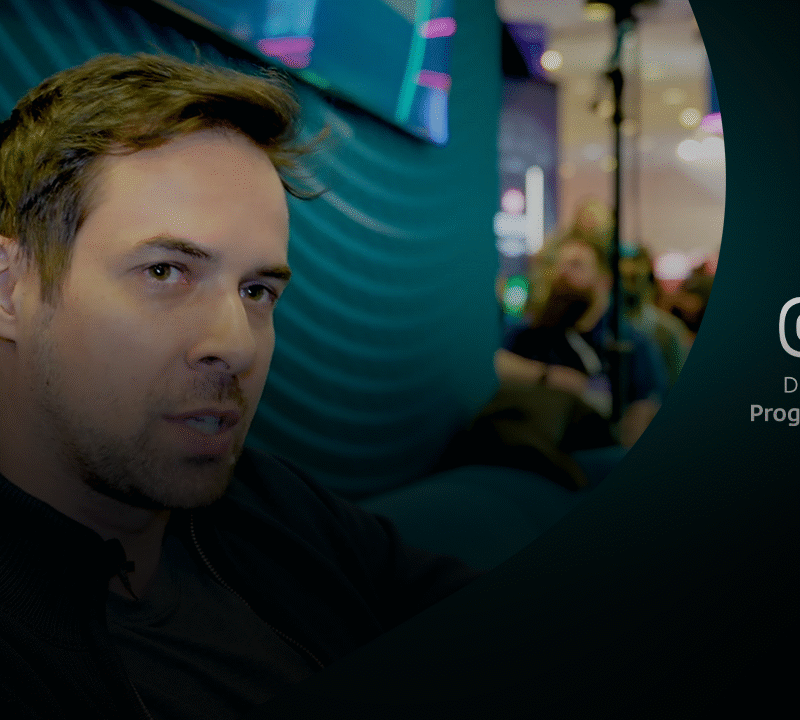 Robert Lipovsky in close-up tijdens interview bij de ESET-stand op een drukke RSA 2025 beursvloer.